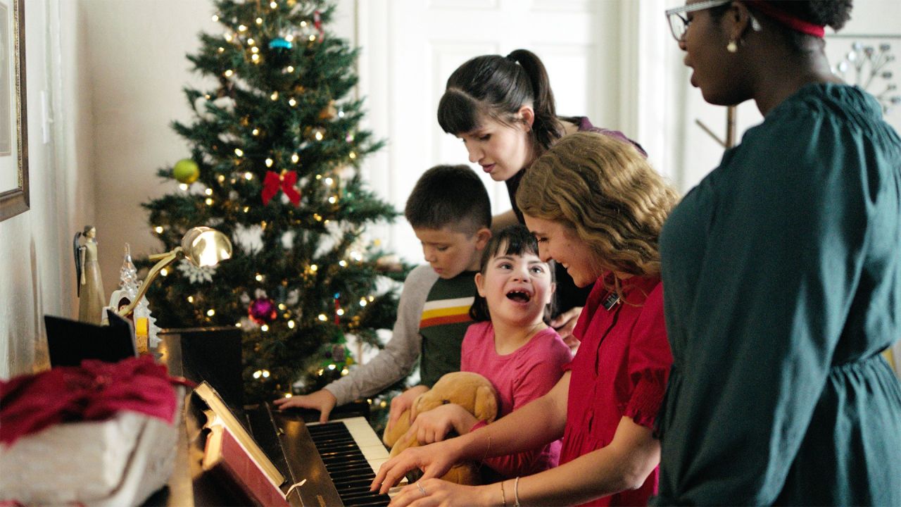 Kızkardeş görevliler bir aile ile piyano çalıyor